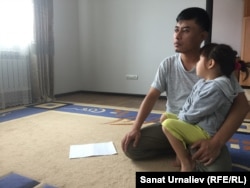 Berikbek Samat, a school teacher from Chapaev, with one of his daughters, whose older sister is currently not attending school because she can't wear a head scarf to classes.