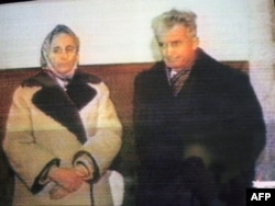 Nicolae Ceauşescu (jobbra) és felesége, Elena Ceausescu a televíziókamerák előtt 1989. december 25-én, a rögtönzött tárgyaláson