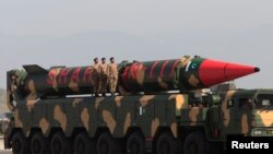 Pakistani military personnel stand beside a Shaheen III surface-to-surface ballistic missile during Pakistan Day military parade in Islamabad, March 2017.