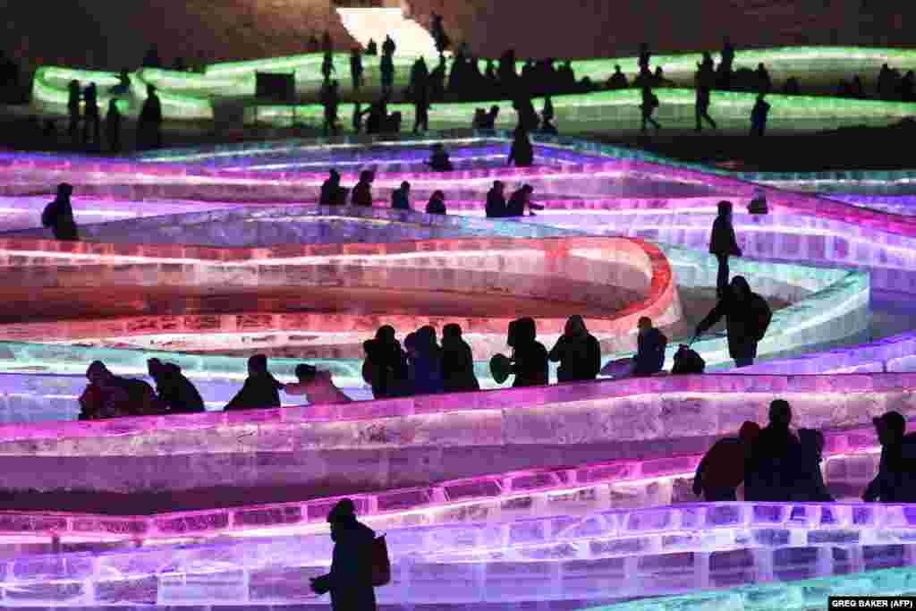 Visitors walk and slide on icy paths on the opening day of the annual Harbin Ice and Snow Sculpture Festival in Harbin in China&#39;s northeast Heilongjiang Province. (AFP/Greg Baker)