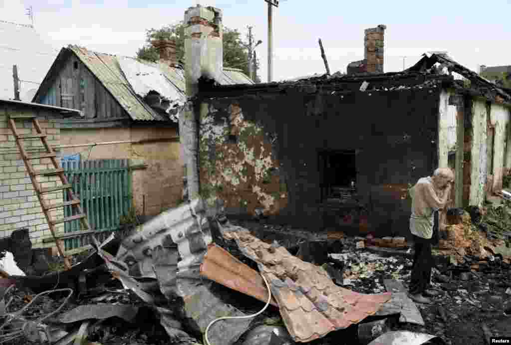 A man cries as he inspects debris while standing outside his damaged house, which, according to locals, was caused by recent shelling, in Donetsk, eastern Ukraine. (Reuters/Alexander Ermochenko)