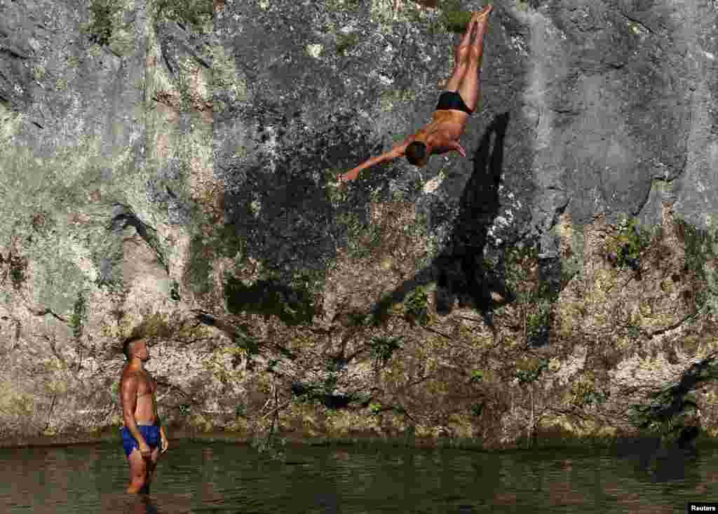 A man jumps during a diving competition in Konjic, Bosnia-Herzegovina. The jumps are performed from a rock platform 18 meters high and into a narrow river pool 2X2 meters wide and 2 meters deep. (Reuters/Dado Ruvic)