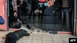 A man lies on the pavement after Turkish antiriot police officers fired tear gas to disperse supporters in front of the headquarters of the Turkish daily newspaper Zaman in Istanbul on March 5.