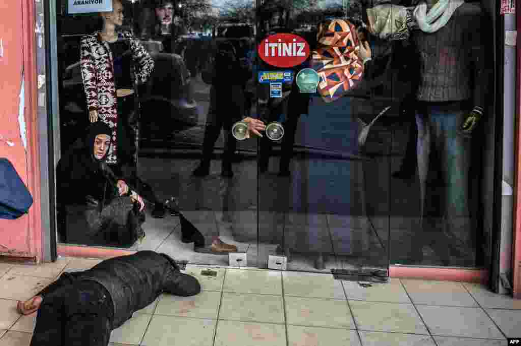 A man lies on the pavement after Turkish antiriot police officers fired tear gas to disperse supporters in front of the headquarters of the Turkish daily newspaper Zaman in Istanbul after Turkish authorities seized the headquarters in a midnight raid. (AFP/Ozan Kose)