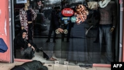 A man lies on the pavement after Turkish antiriot police officers fired tear gas to disperse supporters in front of the headquarters of the Turkish daily newspaper Zaman in Istanbul on March 5.