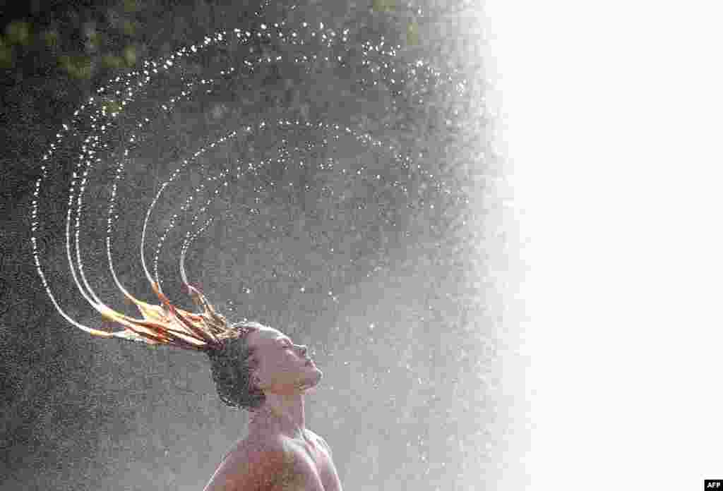 A woman cools off in a fountain in Berli as temperatures topped 30 degrees Celsius. (AFP/dpa/Rainer Jensen)