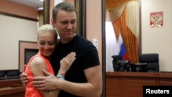 Russian opposition leader Aleksei Navalny embraces his wife, Yulia inside a court building in Kirov in July 2013. 