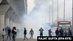 Protesters stand amid smoke during a protest against the Citizen Amendment Act in New Delhi on December 17.
