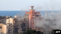 الدخان يتصاعد من احد احياء بنغازي بعد قصف قوات موالية للحكومة مواقع متطرفين 