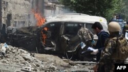 Afghan security forces inspects a damaged vehicle at the site of a suicide bombing attack that targeted NATO forces in Kabul on July 7.