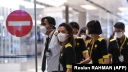 Экипаж самолета авиакомпании Singapore Airlines после прилета из Китая в аэропорт Чанги. Сингапур, 3 марта 2020 года.
