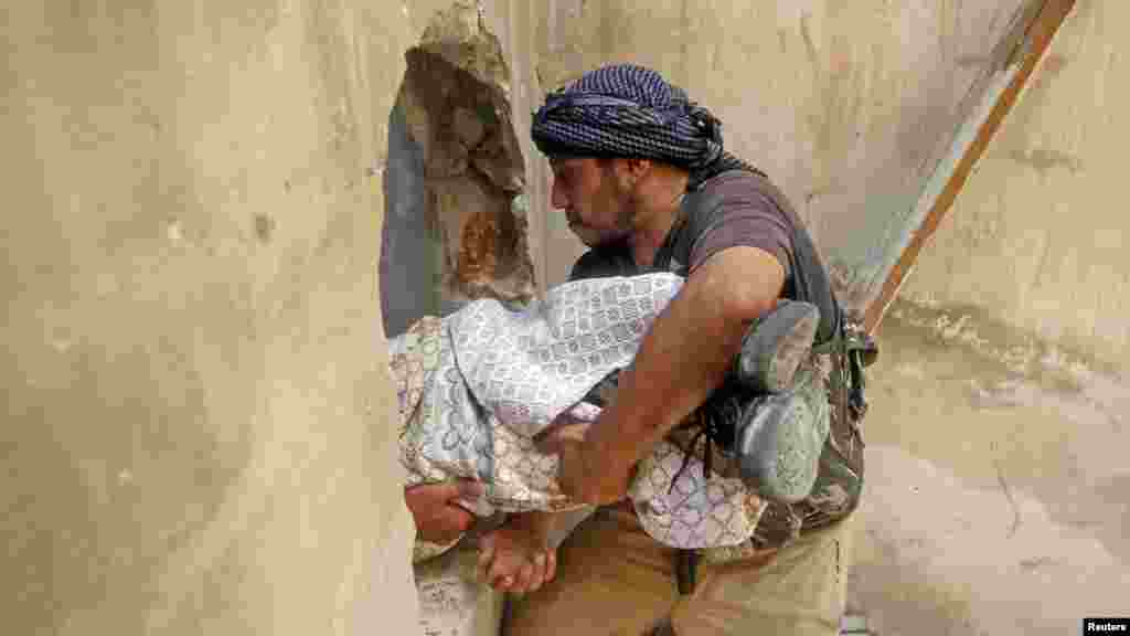 A Free Syrian Army fighter carries the body of a fellow fighter during clashes in Aleppo, Syria. (Reuters/Goran Tomasevic )