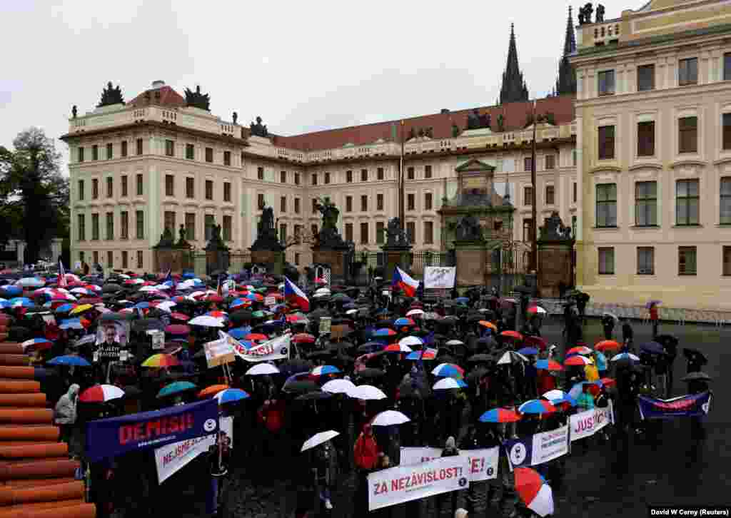 Люди тримають парасольки з кольорами державного прапору Чехії