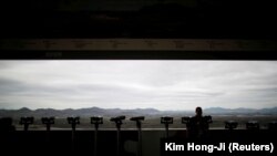 Donald Trump (solda) və Şimali Koreya lideri Kim Jong Un-un fotoları televiziyada göstərilir, arxiv fotosu