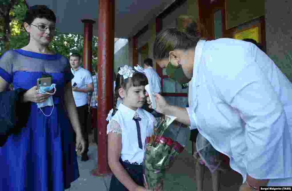 A schoolgirl has her body temperature measured on the first day of classes at the Konstantinovskaya School in Sevastopol, Crimea.