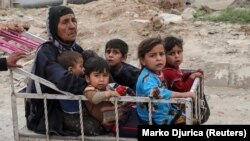 A displaced Iraqi woman and children are seen evacuating as a battle raged between Iraqi forces and Islamic State militants in western Mosul in April 2017.