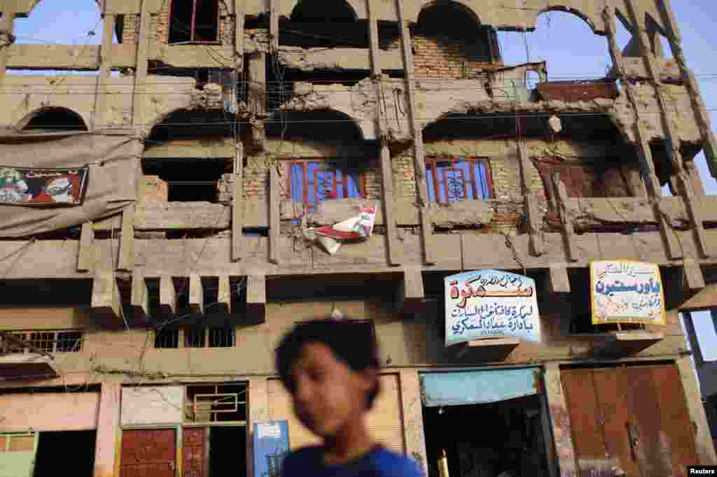 A boy walks past a building in Sadr City, damaged during the 2003 U.S. invasion that toppled Iraqi President Saddam Hussein.