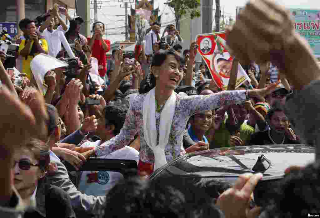 Myanmarın demokratiya tələb edən lideri Aung San Suu Kyi mayın 30-da Taylanda səfəri zamanı iş dalınca bu &ouml;lkəyə getmiş həmvətənlilərini salamlayır. (Reuters/Sukree Sukplang)