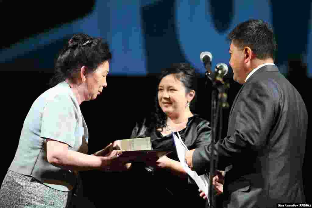 Редакторы кыргызскоязычного сайта радио &quot;Азаттык&quot; Шайырбек Мукарамов и Зейнеп Алтымышова вручают приз одной из победительниц читательского конкурса