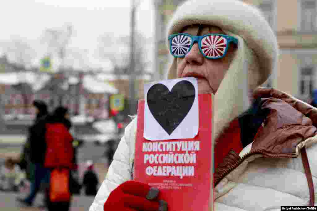 An elderly woman holds a copy of the Russian Constitution as she takes part in the March of Maternal Anger in Moscow on February 10. (TASS/Sergei Fadeichev)