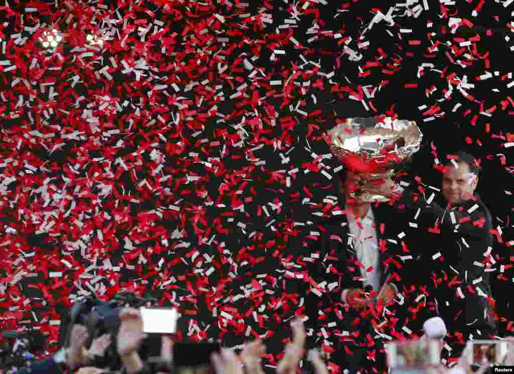 Switzerland's team captain Severin Luethi celebrates with the Davis Cup trophy during a ceremony in Lausanne on November 24, one day after his country won that tennis prize for the first time ever.