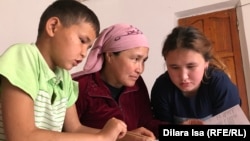 Гульжан Кульбаева с детьми смотрит задания, которые доставили из школы почтой. Туркестанская область, 30 апреля 2020 года.