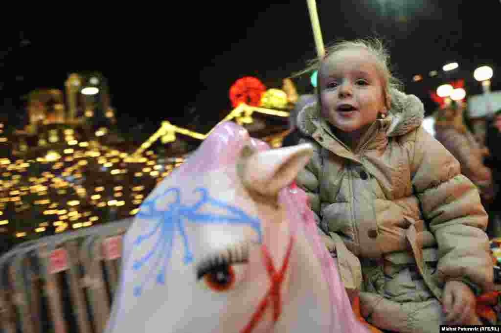 A young girl enjoys the festive atmosphere in Sarajevo before the New Year's holiday. (RFE/RL /Midhit Poturovic)