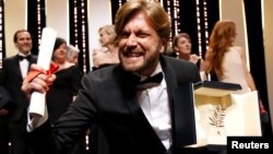 Swedish director Ruben Ostlund celebrates winning the Palme d'Or prize at the Cannes Film Festival.