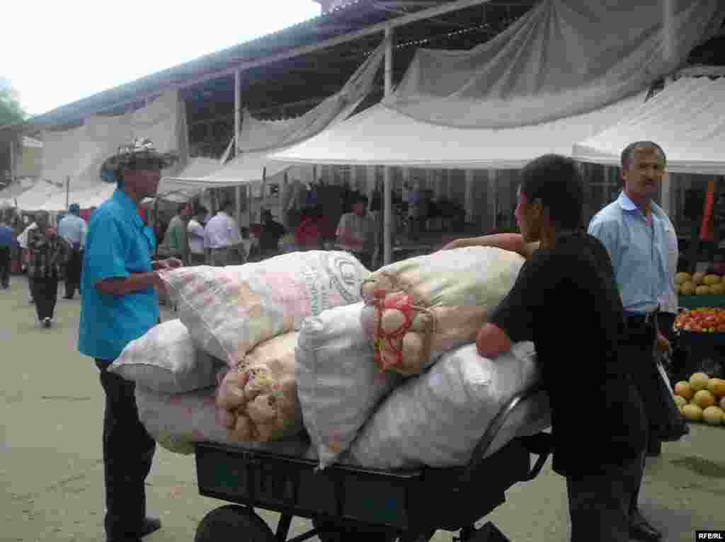 A youth transports a load of vegetables at a market in the Tajik capital, Dushanbe (RFE/RL) - Low-quality education is also a problem in many regions. "Low-quality schools where children experience discrimination or abuse may not seem any more attractive than a hazardous job with a cruel and demanding boss," the ILO reports.