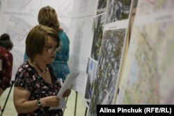 Местная жительница рассматривает проект планировки района