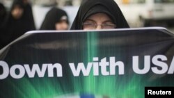  Ирански студент кој е дел од Иранската Револуционерна Гарда протестира пред американската амбасада во Техеран како поддршка за бунтовниците во Бахреин, Либија и Егиепет 