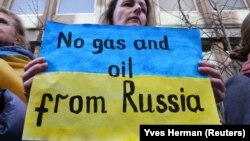 Një grua gjatë një proteste në Bruksel mban një pano ku shkruan: "Jo gaz dhe naftë nga Rusia". Belgjikë, 11 mars 2022.