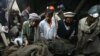 Pakistan -- Rescue workers retrieve the body of one of the miners who was killed in a explosion sparked by methane gas inside a coal mine in Surran range, 20Mar2011