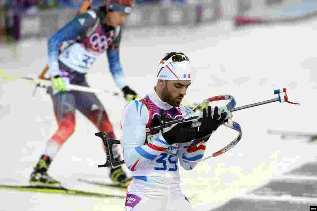 Gold medal winner Simon Fourcade of France (right) and In-Bok Lee of South Korea in action during the men&#39;s 20 kilometer individual competition in the biathlon.