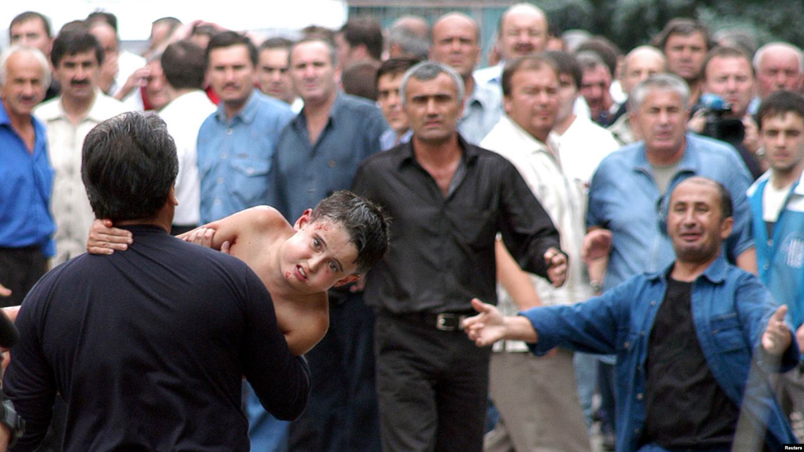  Терактіден жараланған баланы мектептен алып шыққан кез.