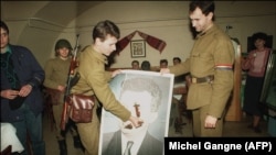 Солдаты режут портрет Чаушеску после его свержения, декабрь 1989