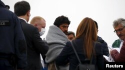 Un migrant însoțit de un ofițer Frontext la îmbarcarea pe un vas în Lesbos pentru a fi returnat în Turcia