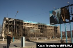 Пострадавший во время Жанаозенских событий фотографирует плакат с портретом президента Нурсултана Назарбаева. Город Жанаозен Мангистауской области, 19 декабря 2011 года