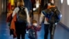 O familie purtând măști chirurgicale, pe aeroportul Otopeni din București