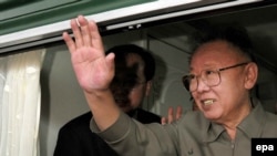 Kim Jong Il waves from a window during his visit to China in May.