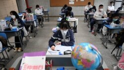Ученици седат на час со маски во училиште во Вухан, мај 2020