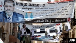 Banners of Egypt's Muslim Brotherhood candidate, Muhammad Morsi (front) and his rival, former leader Hosni Mubarak's last prime minister, Ahmed Shafiq, decorate a street in Cairo.