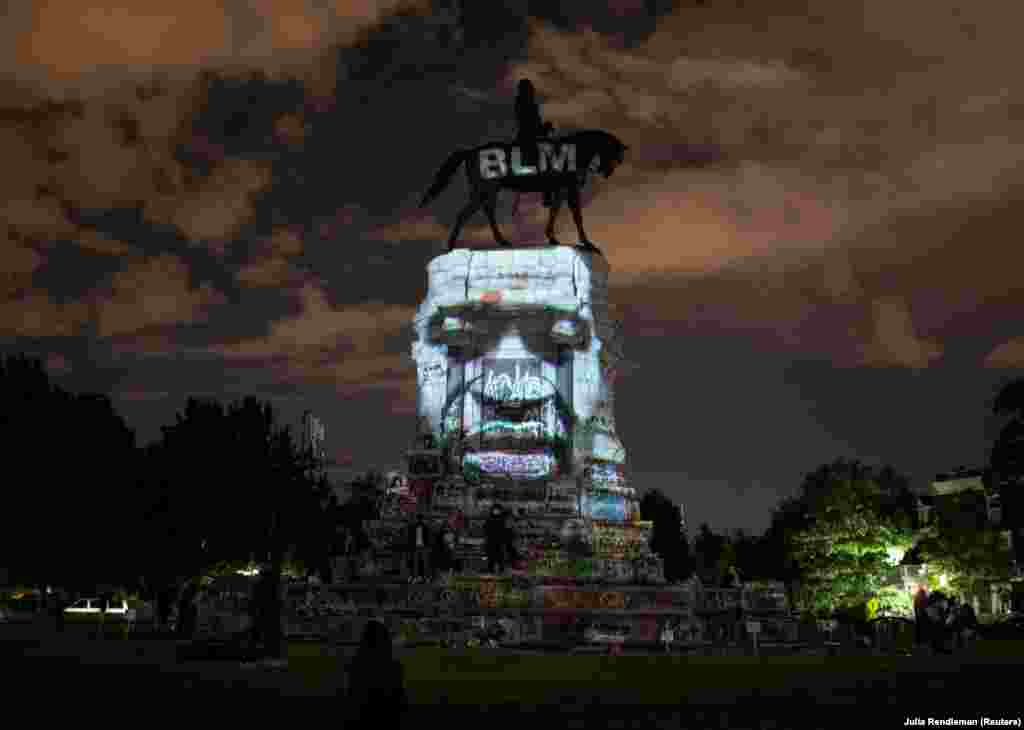 U.S. -- Artist Dustin Klein projects an image of George Floyd onto the statue of Confederate General Robert E. Lee in Richmond, Virginia, U.S. June 18, 2020.