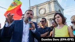 The leader of the Dignity and Truth Platform, Andrei Nastase (left), speaks to protesters in Chisinau on June 20.