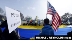 تظاهرات هواداران اوکراین علیه روسیه و ولادیمیر پوتین در مقابل کاخ سفید. در تابلوی سمت چپ نوشته شده که «پوتین یک تروریست است».