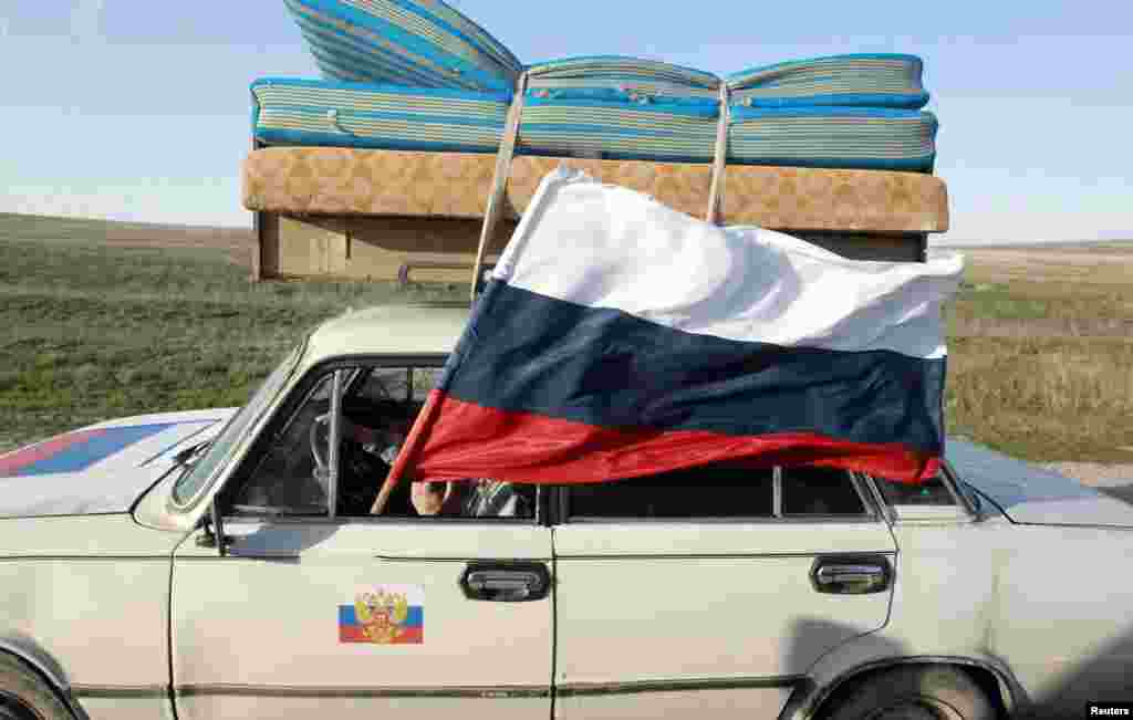 A car flies a Russian flag near the Crimean port city of Feodosia on March 24, shortly after Russia's annexation of the Crimean peninsula. (Shamil Zhumatov, Reuters)