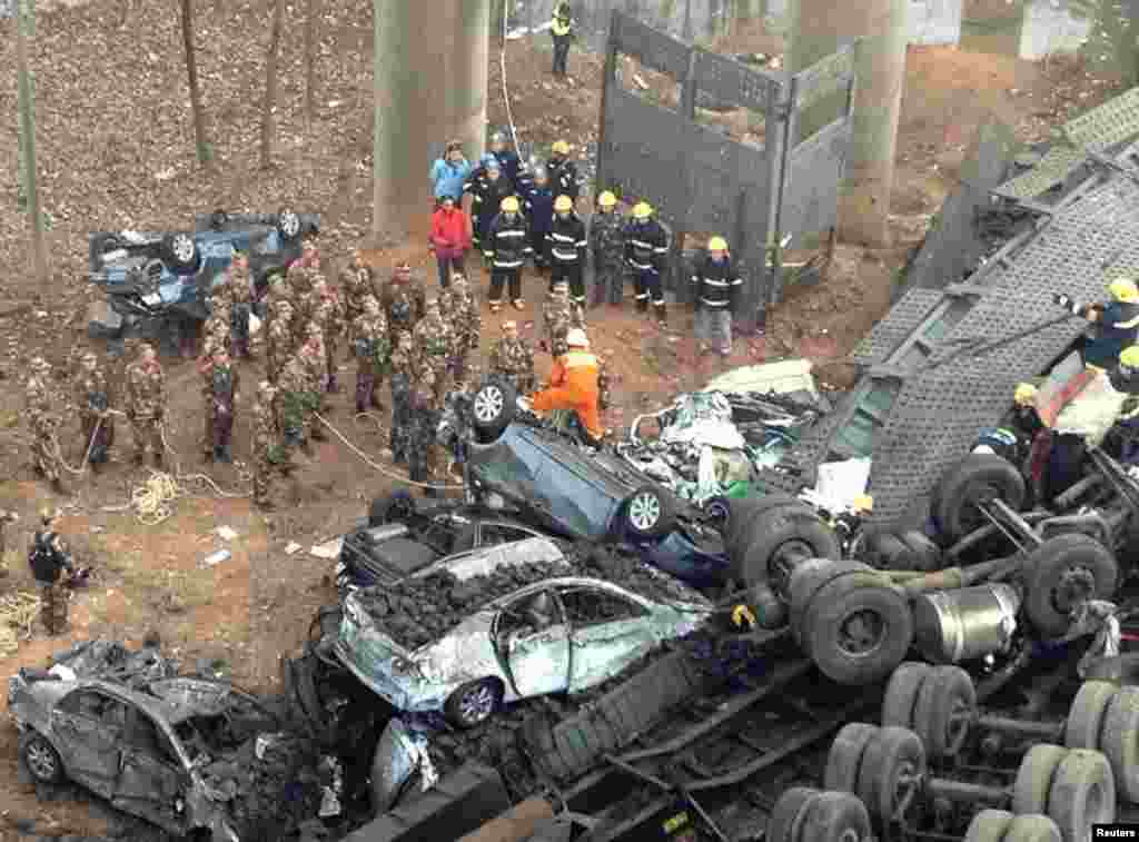 Rescuers look for survivors near the wreckage of vehicles after an expressway bridge partially collapsed due to a truck explosion on the Lianhuo highway in Henan Province. At least five people died and eight others were injured. The truck was loaded with fireworks and the explosion caused several vehicles to tumble from the 30-meter-high bridge. (Reuters)