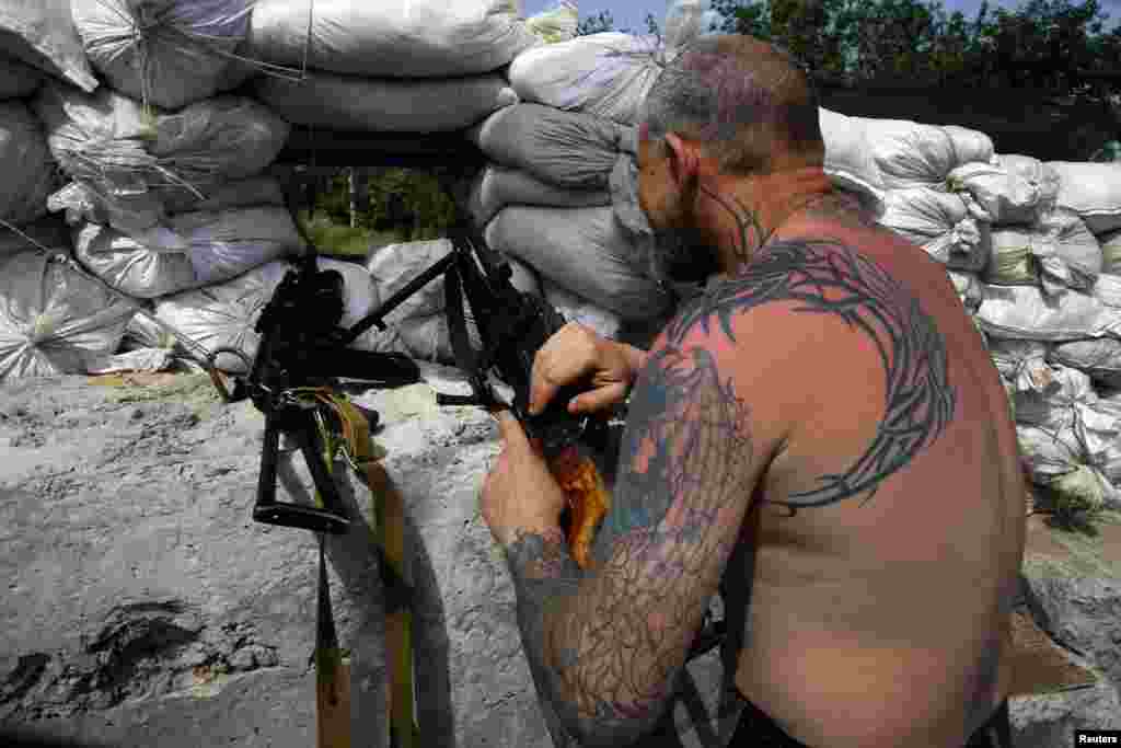 A pro-Russian militant mans a machinegun at front-line rebel position on the outskirts of the eastern Ukrainian town of Slovyansk on May 19. (Reuters/Yannis Behrakis)