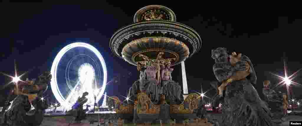 A giant Ferris wheel lights up the night sky for the Christmas holiday season near the fountain on the Place de la Concorde square in Paris. (Reuters/Jacky Naegelen)