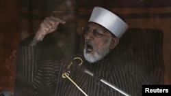 Qadri addresses supporters from behind bulletproof glass in Islamabad.